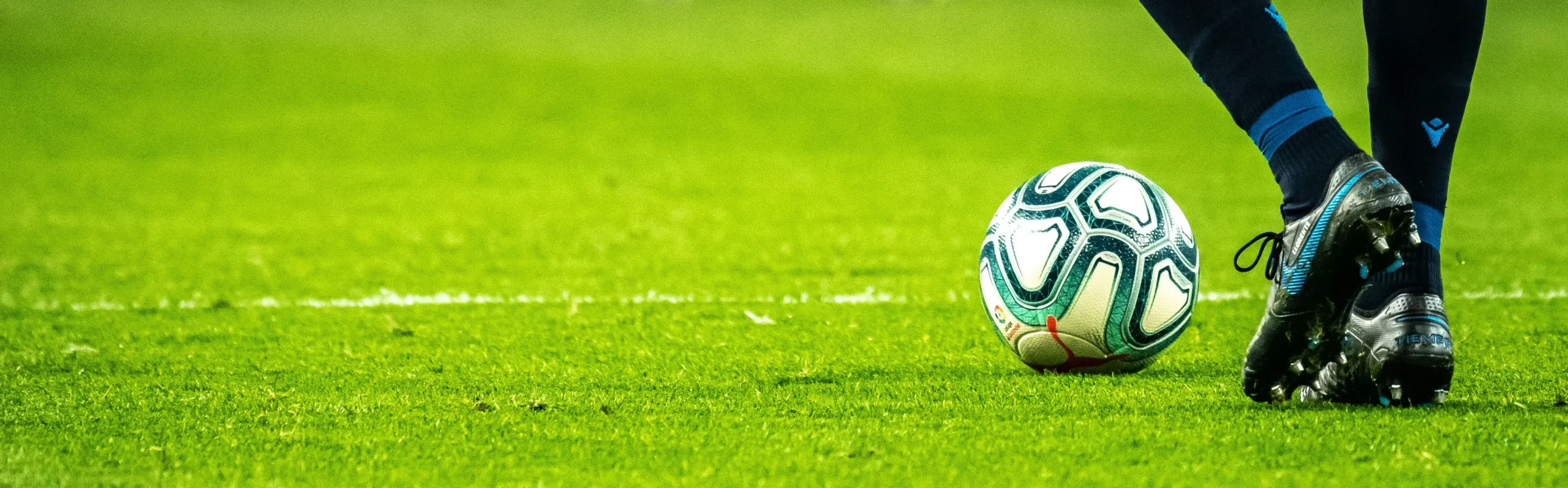 Football resting on grass pitch before training session tracked with football tracker vest system.